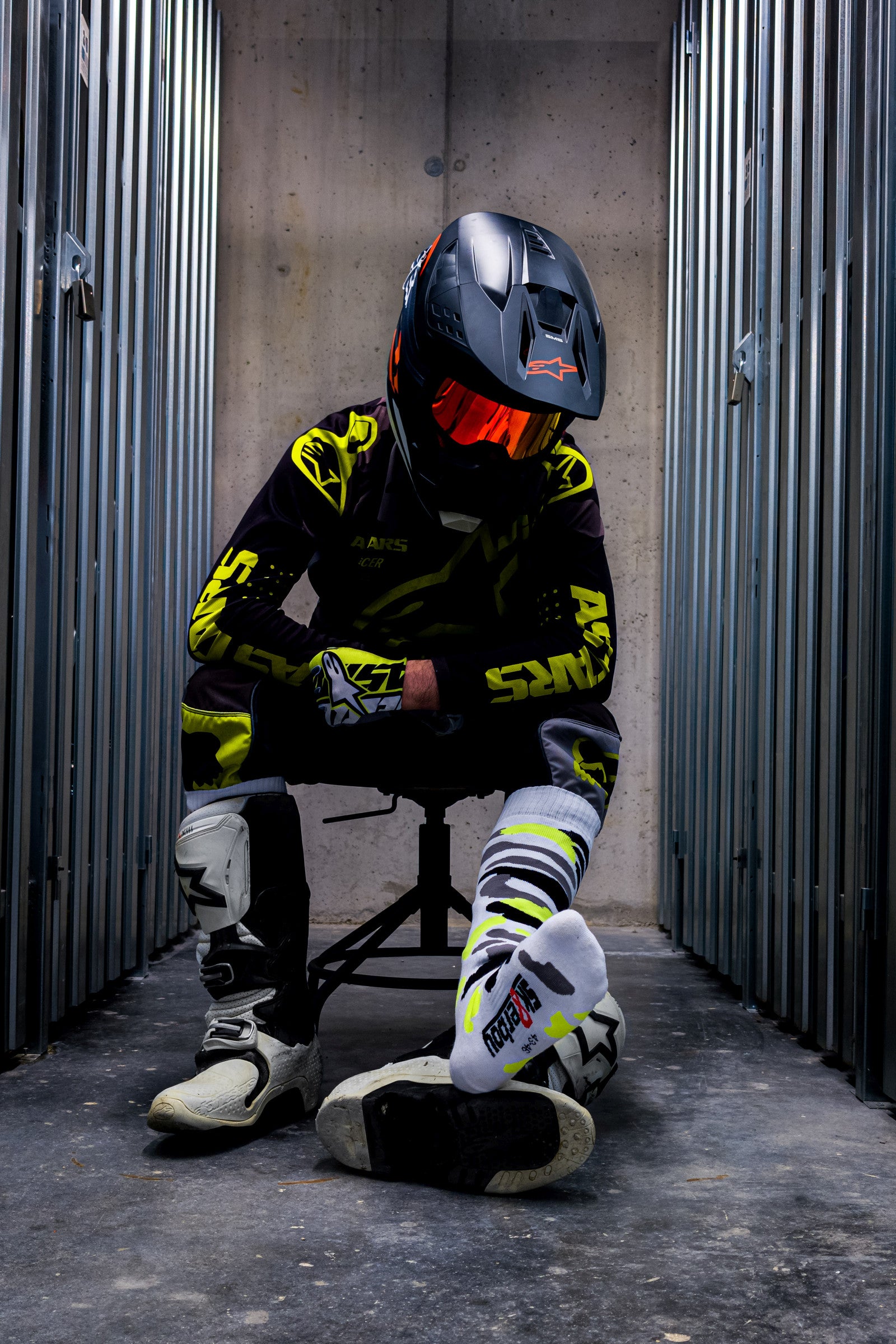 motocross biker in neon gelben dress mit cross boots und mx socks in neon gelb von sk8erboy von vorne in den boots