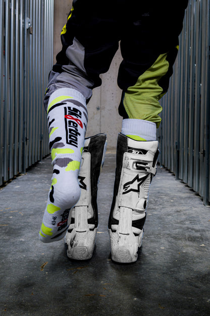 motocross biker in neon gelben dress mit cross boots und mx socks in neon gelb von sk8erboy von hinten in den boots